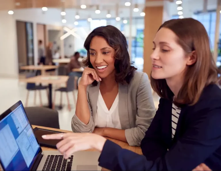 two-businesswomen-with-laptop-at-desk-in-open-plan-2022-02-02-04-50-15-utc-e1676379908582.webp